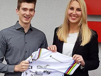Das neue Regenbogentrikot des Weltmeisters ist da: Lukas Kohl hat das Einzelstück selbst anfertigen lassen und mit den Logos seiner Sponsoren verziert. Dieses präsentiert er derzeit seinen Unterstützern, wie der Sparkasse Forchheim um Barbara Eberlein (re.). privat
