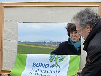 Mit einem Bilderrahmen lenken Dagmar Escher und Hubert Weiger den Blick auf das Gelände für den geplanten Flugplatz. Foto: Rainer Lutz