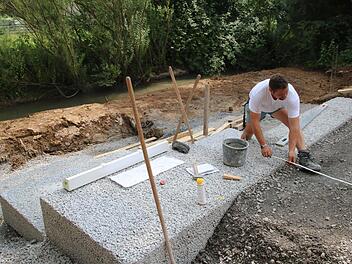 René Rosenbusch arbeitet an dem Lauerzugang, der in der Maßbacher Lauerwiese entstehen soll. Große Stufen sind Treppe und Sitzmöglichkeit in einem. Foto: Heike Beudert