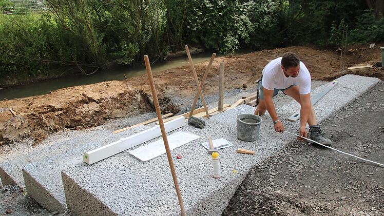 René Rosenbusch arbeitet an dem Lauerzugang, der in der Maßbacher Lauerwiese entstehen soll. Große Stufen sind Treppe und Sitzmöglichkeit in einem. Foto: Heike Beudert