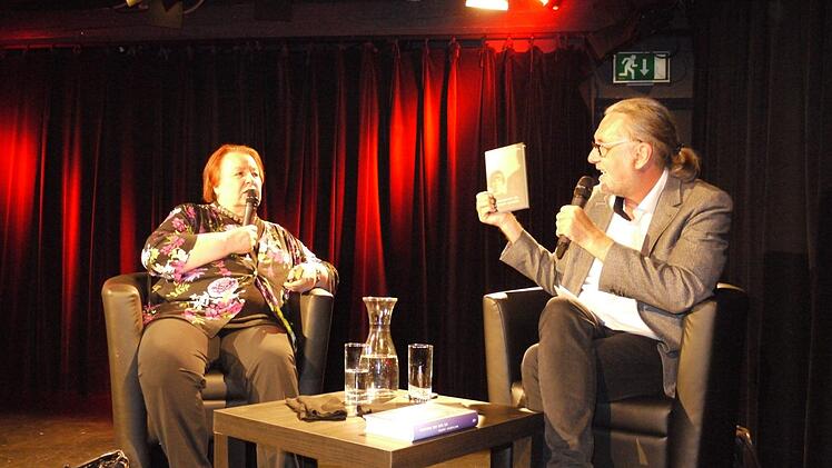 Natascha Wodin und Moderator Dirk Kruse, der ihr neues Werk "Irgendwo in diesem Dunkel" zeigt. Auf dem Umschlag ist die Autorin als elfjähriges Mädchen zu sehen.       Foto: Mike Wuttke