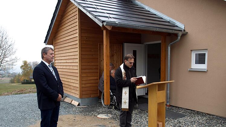 Pfarrer Richard Reis (r.) und Bürgermeister Gerhard  Wunder bei der Segnung des Gemeinschaftshauses in Schlegelshaid.