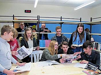 Auch Zeitschriften finden sich in der neu gestaltete Schülerbibliothek der Realschule CO I. Bürgermeister Thomas Nowak beobachtet das fröhliche Treiben der Schüler durch das Bücherregal.  Foto: Martin Koch