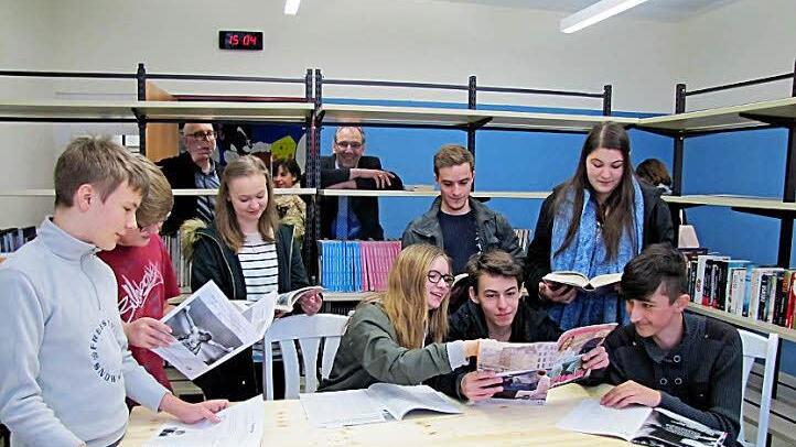 Auch Zeitschriften finden sich in der neu gestaltete Schülerbibliothek der Realschule CO I. Bürgermeister Thomas Nowak beobachtet das fröhliche Treiben der Schüler durch das Bücherregal.  Foto: Martin Koch