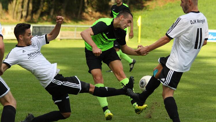 Gemeinsam blocken die Weingartser Andreas Liebel (l.) und Matthias Werner den Schussversuch von Elias Georgiadis (TSV Neunkirchen). Mit 4:0 behielt die DJK im Derby der Kreisliga 2 am Ende die Oberhand.  Foto: Uwe Kellner