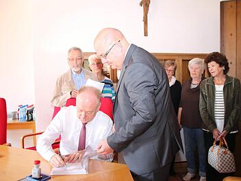Bürgermeister Helmut Blank bestätigt mit seiner Unterschrift den Eingang des Bürgerbegehrens. Zuvor hatte geschäftsleitender Beamter Stefan Bierdimpfl (rechts vorne) die Unterschriftenlisten gezählt. Fotos: Heike Beudert