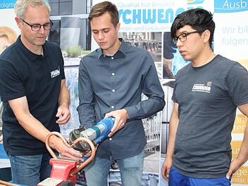 Bernd Münch von der Firma Schwender zeigt Florian El-Sayed (Mitte), wie man mit einer Fitting-Presse ein Kupferherz zusammenpresst. Lehrling Mohammed Zaki Sharifi (rechts) schaut zu. Foto: Stephan Stöckel