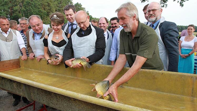 Ministerialdirigent Friedrich Mayer (vorne in Schwarz mit Brille) hat am Willersdorfer "Erleinsee" die bayerische Karpfensaison eröffnet. Die Karpfenkönigin (Zweite von links) ist auch vor Ort.