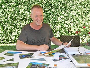 Andreas Christl legt die Unterlagen zu seinem Vorhaben im Sonnefelder Gewerbegebiet auf den Tisch. Foto: Rainer Lutz