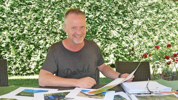 Andreas Christl legt die Unterlagen zu seinem Vorhaben im Sonnefelder Gewerbegebiet auf den Tisch. Foto: Rainer Lutz