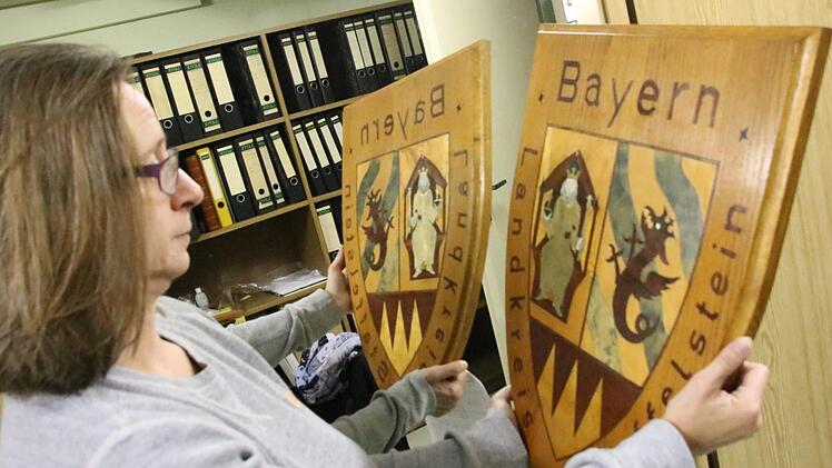 Die Staffelsteiner Museumsleiterin Adelheid Waschka zeigt eines der letzten Relikte des Landkreises Staffelstein: Dieses 1980 von Max Förster aus Unterzettlitz handgefertigte Landkreiswappen hing wohl  im Amtszimmer des Staffelsteiner Bürgermeisters Reinhard Leutner. Foto: Matthias Einwag