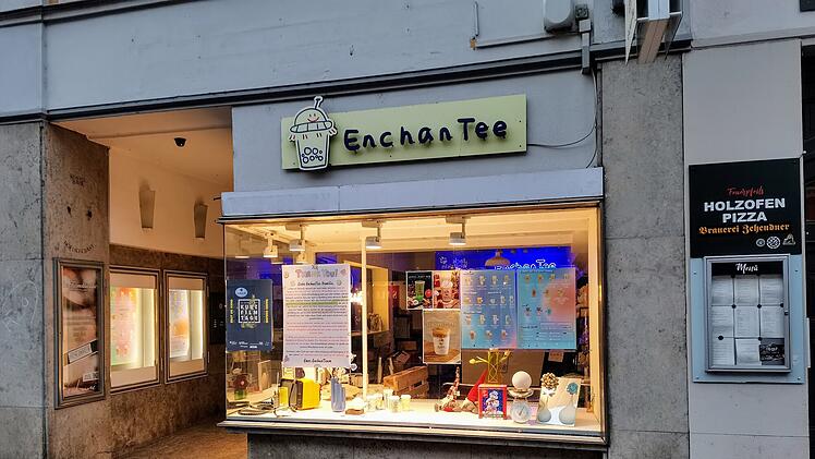 Ein hell beleuchtetes Teefachgeschäft namens "EnchanTee" in Bambergs Innenstadt schließt bald. Das Schaufenster zeigt verschiedene Teeprodukte und Dekorationen.