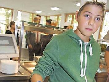 Einige Jungs aus der achten Klasse haben Kürbissuppe als Vorspeise gezaubert: Caspar Schweens (13) ist für die Garnitur mit Petersilie und Kürbiskernen zuständig. Foto: Sonja Adam