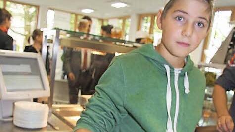 Einige Jungs aus der achten Klasse haben Kürbissuppe als Vorspeise gezaubert: Caspar Schweens (13) ist für die Garnitur mit Petersilie und Kürbiskernen zuständig. Foto: Sonja Adam