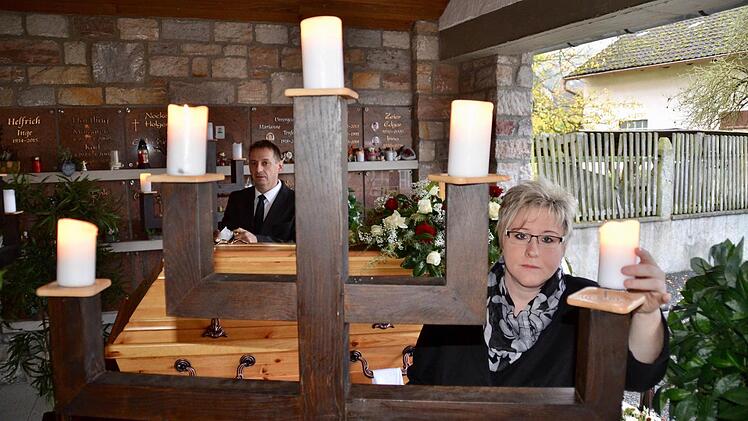 Das Dekorieren und Arbeiten in der Leichenhalle kurz vor der Beerdigung mag Yvonne Hergenröder am liebsten. Hier zünden sie und ihr Mann Heiko die Kerzen der mannshohen Leuchter an. Foto: Kathrin Kupka-Hahn