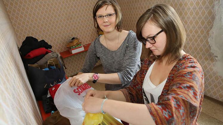 Die Studentinnen Saskia Schlenstedt (links) und Stephanie Lanzinger sortieren im Lager die Kleidung, die abgegeben wurde. Foto: Barbara Herbst