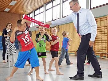 Kampfkatzen trainieren in der Grundschule: Mit Unterstützung der Krankenkasse Audi BKK (im Bild rechts der Service-Center-Leiter Klaus Fuchs) kann die Grundschule Ebern im Rahmen des Ganztags den Erstklässlern das Sportprojekt "Kampfkatzen" anbieten. Jürgen Schorn vom Sportstudio Schorn trainiert mit den Kindern über einen Zeitraum von zehn Wochen.  Foto: Johanna Eckert