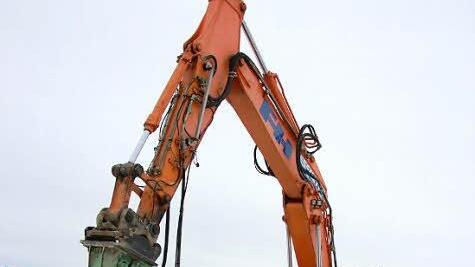 Ein Bagger war gestern mit einem Bohrhammer dabei, Teile der Zufahrt zur alten Eisenbahnbrücke zu zerlegen.