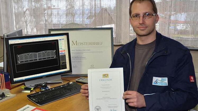 Jungmeister Thorsten Föhrweiser am Konstruktionsplaner und dem Meisterbrief als Metallbauermeister. Er hält die Urkunde, die er zum Meisterpreis der Bayerischen Staatsregierung für die hervorragend absolvierte Meisterprüfung erhielt. Foto: Karl-Heinz Hofmann