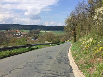 Die Sanierung der Straße am  Berg nach Motschenbach (im Hintergrund)  war großes Thema in der Bürgerversammlung am Montagabend im Sportheim. Foto: Jürgen Gärtner