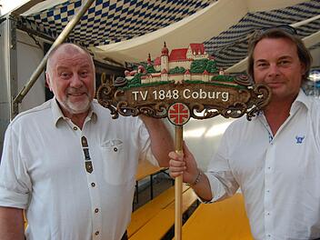 Vorsitzender Gerhard Fleißner (links) und sein Stellvertreter Hubertus Volk mit dem handgeschnitzten Wappen des TV 1848 Coburg. Foto: Oliver Schmidt