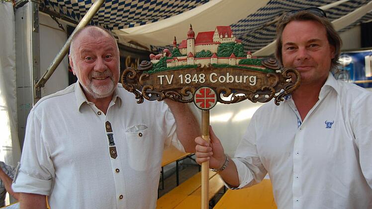 Vorsitzender Gerhard Fleißner (links) und sein Stellvertreter Hubertus Volk mit dem handgeschnitzten Wappen des TV 1848 Coburg. Foto: Oliver Schmidt