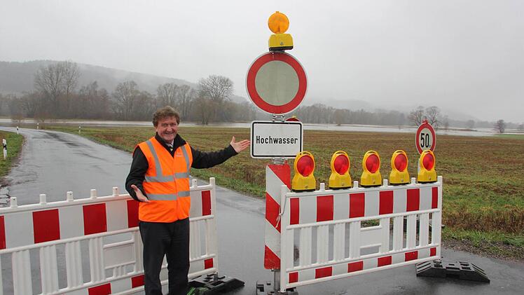 Der Mitwitzer Bürgermeister Hans-Peter Laschka an der Hochwassersperre. "Sorry, kein Durchkommen", bedauert er. Im Hintergrund sieht man die Wassermassen der Steinach. Foto: Friedwald Schedel