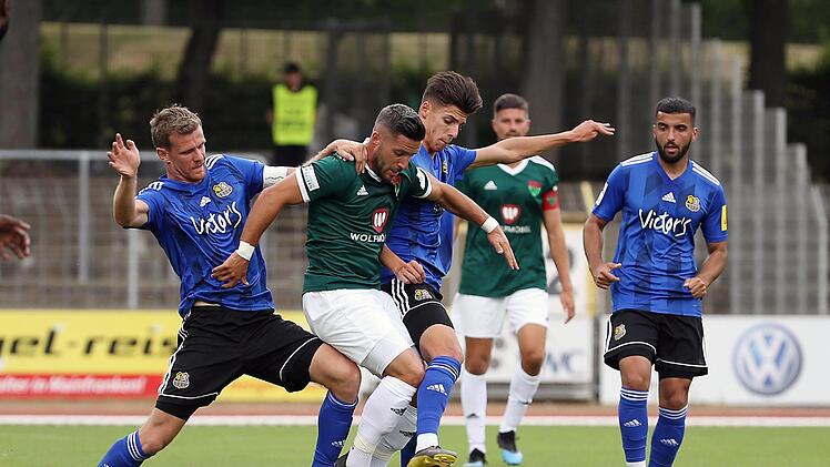 Allein gegen Zwei: Schweinfurts Sascha Korb (grün) setzt sich gegen die Saarbrückener Manuel Zeitz (links) und Ivan Franjic durch. Hinten beobachtet 05-Kapitän Stefan Kleineheismann die Szene.  Foto: Scheuring
