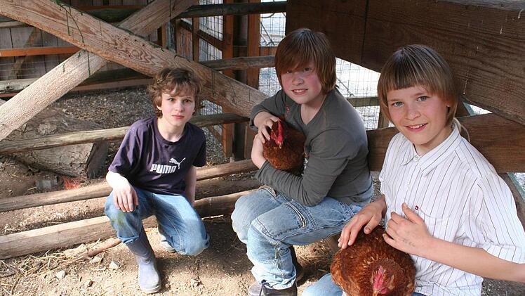 Piak, Hannes und Enrico mit ihren Lieblingshühnern Dopsie und Hanna (von links)