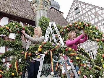 Die Schwestern Jasmin und Dominika helfen mit, den Kriegerbrunnen am Rathausplatz zu schmücken.  Foto: Josef Hofbauer