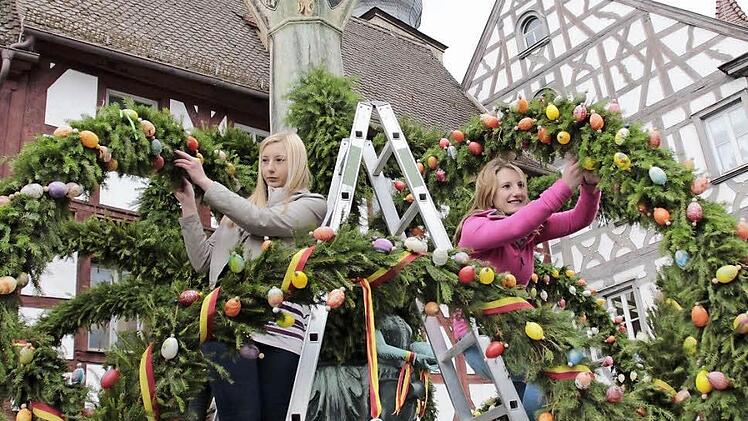 Die Schwestern Jasmin und Dominika helfen mit, den Kriegerbrunnen am Rathausplatz zu schmücken.  Foto: Josef Hofbauer