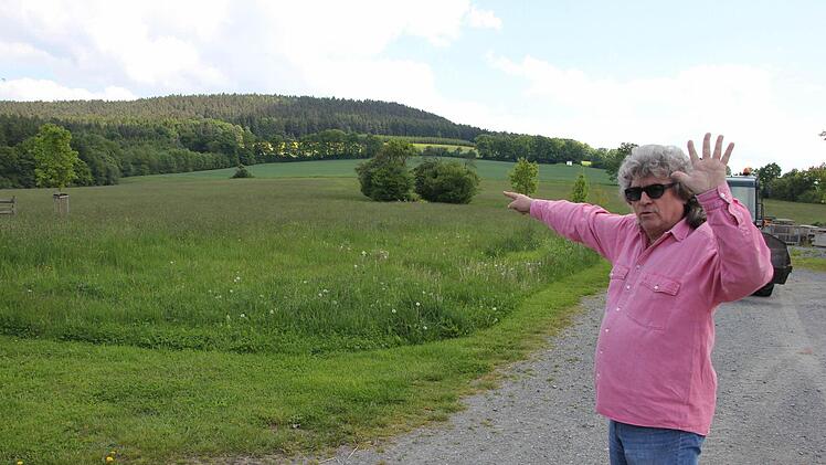 Fünf große Windräder sind auf dem Reinberg geplant, deutet Helmut Schiffner mit der linken Hand an und zeigt mit der rechten Hand auf den Höhenzug, auf dem die Windräder errichtet werden sollen. Deren Rotoren würden bis zum oberen Bildrand ragen. Foto: Friedwald Schedel