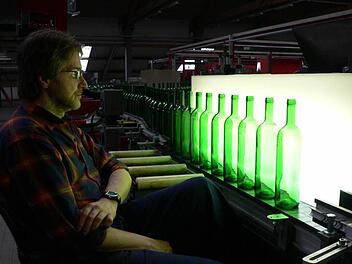 Ein Wiegand-Glas-Mitarbeiter   prüft die Qualität neuer Weinflaschen. Foto: M. Litzlfelder, Archiv