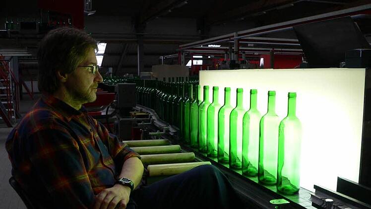 Ein Wiegand-Glas-Mitarbeiter   prüft die Qualität neuer Weinflaschen. Foto: M. Litzlfelder, Archiv