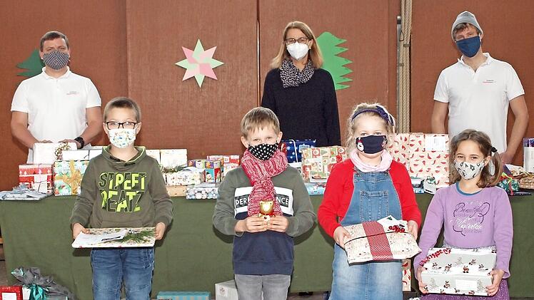 Vier Kinder aus der Klasse D1A der St.-Katharina-Schule nahmen ihre Geschenke von den beiden Siemens-Healthineers-Mitarbeitern Michael Kaden (links) und Benedikt Debel (rechts) im Beisein der Schulleiterin Ute Donhauser (Mitte) entgegen. Foto: Alfred Thieret