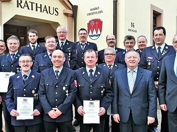 Bürgermeister Gotthard Schlereth (von rechts) und Landrat Thomas Bold mit den ausgezeichneten Feuerwehrmännern der Marktgemeinde Oberthulba.  Fotos: Sigismund von Dobschütz