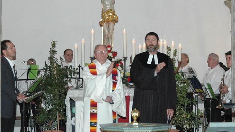 Pfarrer Roland Breitenbach (vorne links) und Dekan Jürgen Blechschmidt verteilten gemeinsam den Segen an die Gottesdienstbesucher. Im Hintergrund ist der kleine Bezirksposaunenchor mit Chorleiter Jürgen Koch (ganz links) zu sehen. Foto: Schmidt