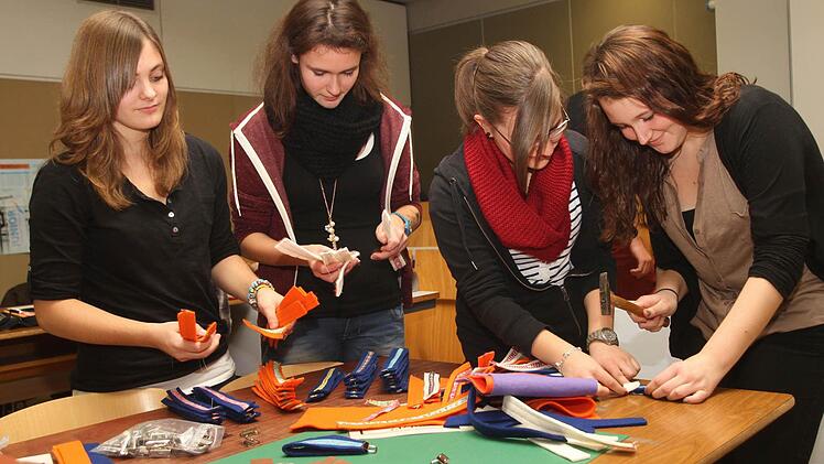 Die Filz-Enden mit einem Metallband durch Hammerschläge zu verschließen, gestaltete sich für die Mitarbeiterinnen  nicht so einfach. Von links Alina Rippstein, Alexandra Rauscher, Anna Fischer und Mandy Artzt. Foto: gg