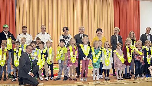 Oliver Skall von der AOK (vorne) &uuml;berreichte den frischgebackenen Erstkl&auml;sslern der Grundschule Stockheim reflektierende Warnwesten.