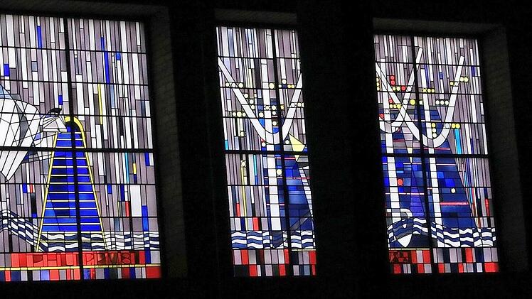 Zwölf Tore mit den Namen der Apostel (auf rotem Fundament), dargestellt in den Kirchenfenstern der Pfarrkirche Verklärung Christi, führen in die Heilige Stadt.  Foto: Josef Hofbauer