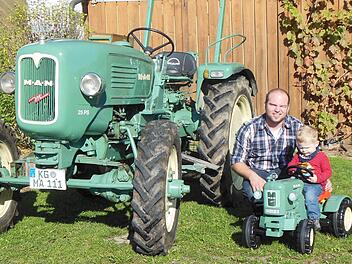 Alexander Morber und sein Patenkind Hannes freuen sich über ihre MAN-Traktoren. Foto: Berthold Morber