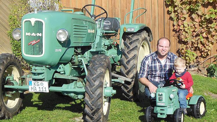 Alexander Morber und sein Patenkind Hannes freuen sich über ihre MAN-Traktoren. Foto: Berthold Morber