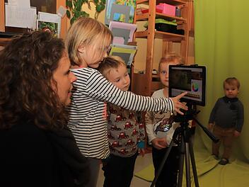Gemeinsam mit Medien-Coach Katharina Nierhoff probieren Eva, Emil und Lena (von links) aus, was man mit dem neuen Tablet alles machen kann. Lias, der zu den Jüngsten im Kindergarten gehört, schaut noch etwas skeptisch zu. Fotos: Katrin Geyer