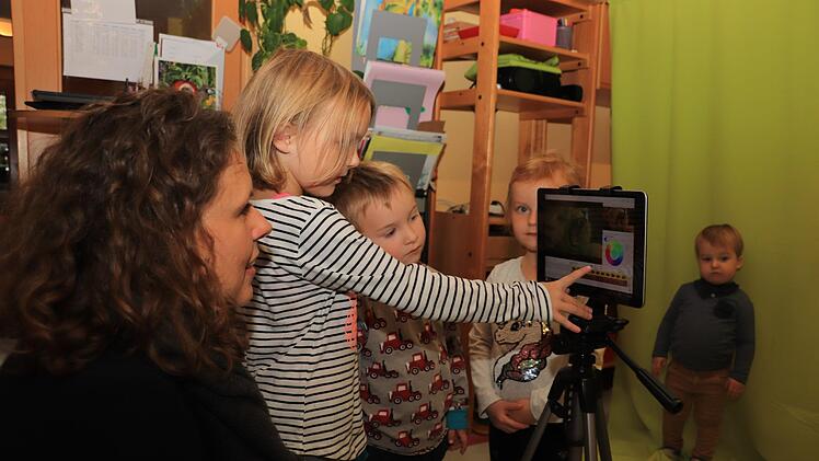 Gemeinsam mit Medien-Coach Katharina Nierhoff probieren Eva, Emil und Lena (von links) aus, was man mit dem neuen Tablet alles machen kann. Lias, der zu den Jüngsten im Kindergarten gehört, schaut noch etwas skeptisch zu. Fotos: Katrin Geyer