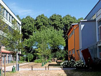Zwischen der Mittelschule (links) und der Grundschule (rechts) soll im Hintergrund bei der Bäumefront der Anbau für die Grundschule entstehen.