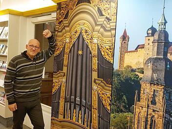 Zwischen Orgel, Prospekten und der Veste: Horst Graf in der umgestalteten Tourist-Info in der Herrngasse. Die großen Bilder sollen neugierig machen auf Coburg. Foto: Simone Bastian
