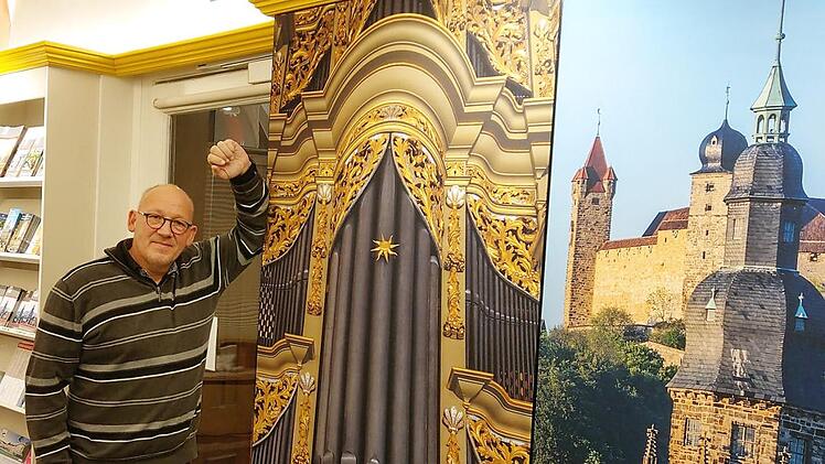 Zwischen Orgel, Prospekten und der Veste: Horst Graf in der umgestalteten Tourist-Info in der Herrngasse. Die großen Bilder sollen neugierig machen auf Coburg. Foto: Simone Bastian