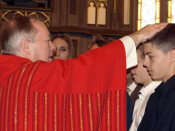 Generalvikar Georg Kestel firmt Christopher Schmidt mit dem Chrisam-Öl. Foto: Susanne Deuerling
