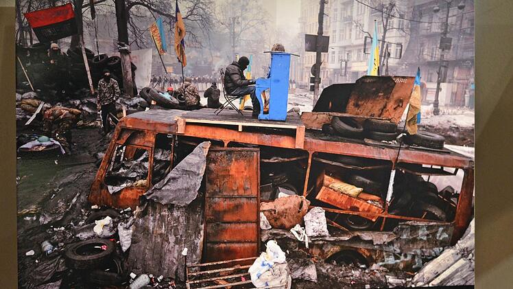 Der Mann mit der Maske, der Pianist-Extremist genannt wurde, spielt auf einem Klavier, das man auf einem Dach eines verbrannten Polizeibusses aufgebaut hatte. Foto: Nikolas Pelke