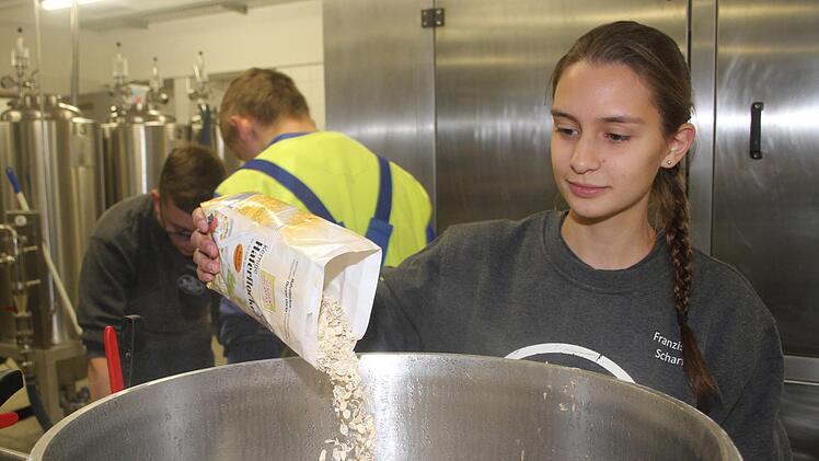 Franziska Scharf gibt Haferflocken in den Sud, um das Fett aus den Walnüssen zu binden. Foto: Sonny Adam
